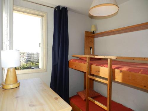 - une chambre avec des lits superposés, une table et une fenêtre dans l'établissement Appartement Familial 3 Pièces, 6 Couchages, Proche Plage et Commerces - Bormes-les-Mimosas - FR-1-251-798, à Bormes-les-Mimosas