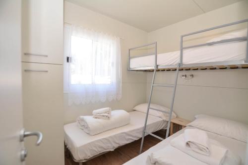 een kamer met 2 stapelbedden en een spiegel bij Mobilhome Camping Azzurro in Ledro