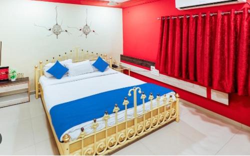 a bedroom with a bed with blue and red walls at Hotel Suraj Inn in Surat