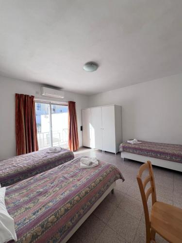a hotel room with two beds and a table at Garden View Apartment No 39 in Tal-Franċiż