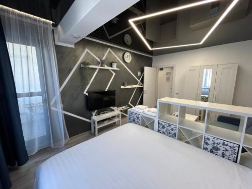 a bedroom with a white bed in a room at Perla Home - Studio 9 in Popeşti-Leordeni