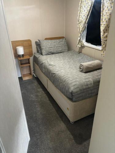 a small bedroom with a bed and a window at Ataraxia - Ocean Edge Resort - 8 Berth Accommodation in Heysham