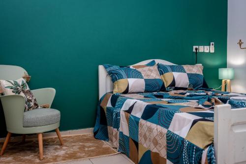 um quarto com uma cama e uma parede verde em APPARTEMENT KUAMINA em Lomé
