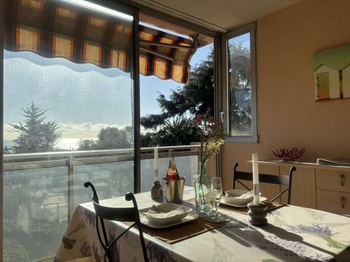 une table à manger avec des bougies et une grande fenêtre dans l'établissement Studio agréable avec loggia, garage et plage à proximité - 2 couchages, Golfe-Juan - FR-1-252-62, au Golfe-Juan