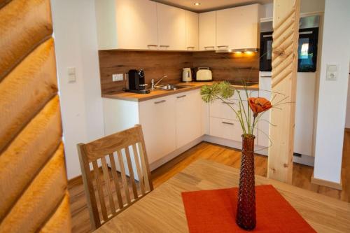 una cocina con una mesa y un jarrón con flores. en Ferienwohnung Mopsfidel, en Pfronten