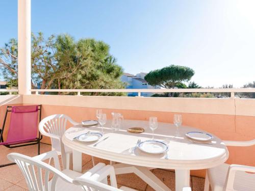 une table blanche et des chaises sur un balcon dans l'établissement Appartement T4 Duplex 6 Pers, Balcon, Garage - Narbonne-Plage - FR-1-409-50, à Narbonne-Plage