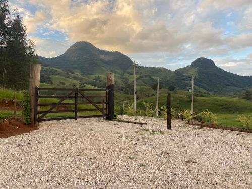 a wooden gate with a view of a mountain at Chalé Magia do Serrano in São Bento do Sapucaí