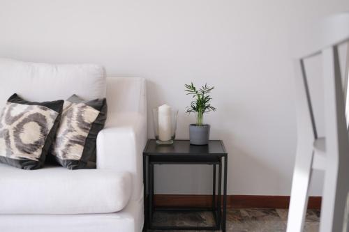 un divano bianco con tavolino e una pianta di Appartamento 25 min da Venezia a Quarto dʼAltino
