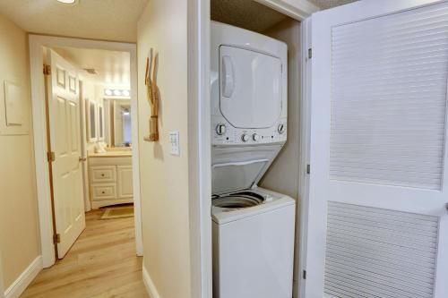 Waschmaschine und Trockner in einem kleinen Zimmer mit Tür in der Unterkunft Land's End 1-202 Bay Front in St Pete Beach