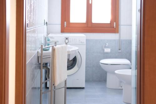 a bathroom with a sink and a washing machine at Toscanini Apartment - perfect for Venice by train in Quarto dʼAltino