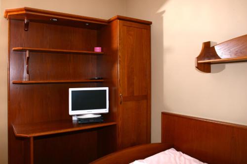a bedroom with a desk with a computer monitor on it at Penzion FAJN *** in Pardubice