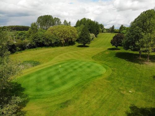 een uitzicht over een groene golfbaan bij The Crown at Shipton in Shipton under Wychwood