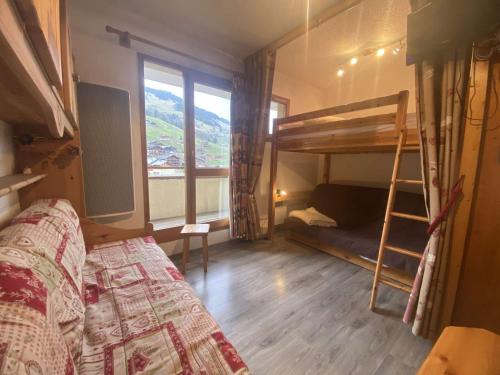 une chambre avec un lit superposé et une échelle dans l'établissement Appartement rénové cosy avec piscine, pour 4 personnes, proche des pistes et du village. - FR-1-342-180, à Arêches