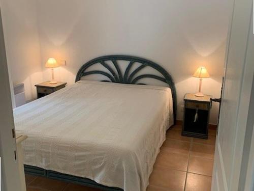 - une chambre avec un lit et deux lampes sur les tables dans l'établissement Appartement T3 avec grand jardin privé, climatisation et parking - FR-1-100-205, à Cavalaire-sur-Mer