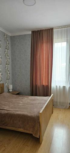 a bedroom with a large bed and a window at Guest House Bochora in Borjomi