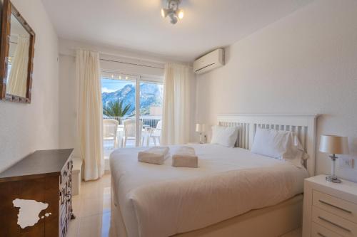 ein Schlafzimmer mit einem großen weißen Bett und einem Balkon in der Unterkunft CostaBlancaDreams Apartment Gran Sol in Calpe in Calpe
