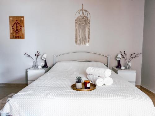 białe łóżko z 2 poduszkami i tacą z ręcznikami w obiekcie Iria Apartment w mieście Polijiros