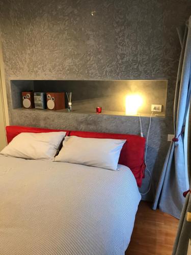 um quarto com uma cama com almofadas vermelhas e brancas em Casa Nirvana em Gênova