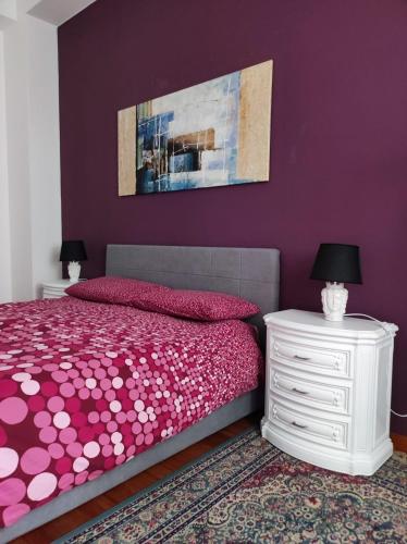 a purple bedroom with a bed and a white nightstand at ''A casa di Lele'' in Avola