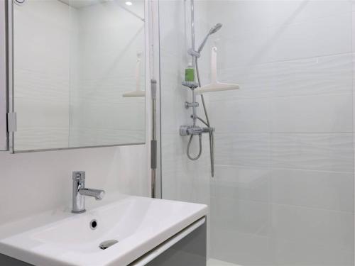 une salle de bain blanche avec un lavabo et une douche dans l'établissement Bel appartement rénové face au port avec loggia et garage privé à Perros-Guirec - FR-1-368-283, à Perros-Guirec