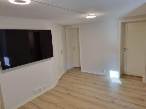 a living room with a flat screen tv on a wall at Leilighet nær Trondheim by. in Trondheim