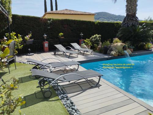 a swimming pool with chairs and a table and a swimming pool at Les arbousiers in La Cadière-dʼAzur