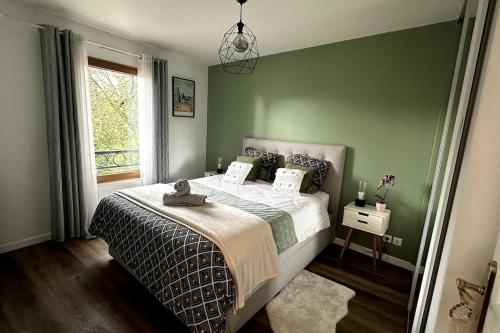 een groene slaapkamer met een bed en een raam bij 2024 Olympics - 20 min de Paris in Aulnay-sous-Bois
