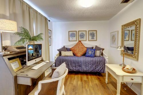 a bedroom with a bed and a desk with a computer at Blue Beach Cottage in St. Pete Beach