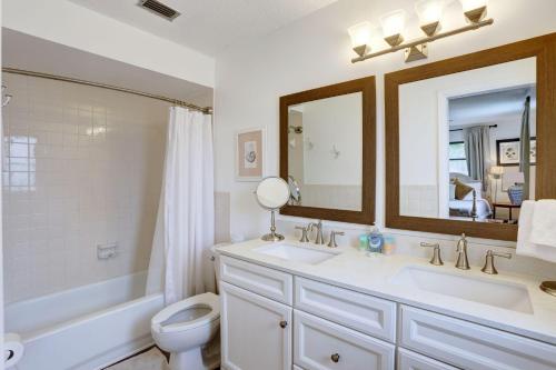 a bathroom with a sink and a toilet and a mirror at Blue Beach Cottage in St. Pete Beach