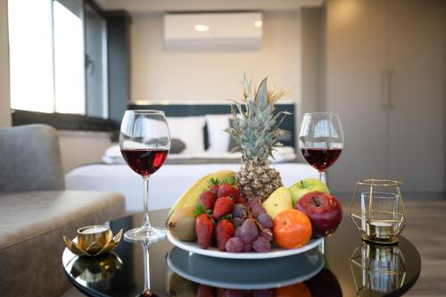 a plate of fruit on a table with two glasses of wine at Swans Hotel Old City Grand Bazaar in Istanbul