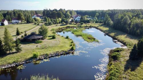 an aerial view of a river with a house at Gospodarstwo Agroturystyczne Zasadkowe Bory in Rogowo
