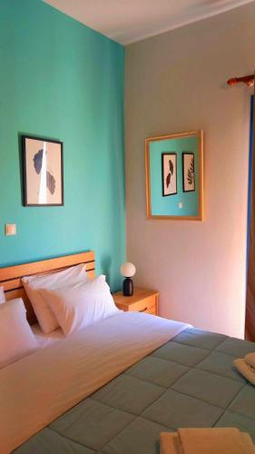 a bedroom with a bed and two pictures on the wall at Στούντιο με θέα τη θάλασσα in Itea