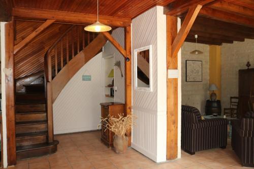 a living room with a staircase in a house at L'autre Monde Chambres D'hôtes in Faverolles