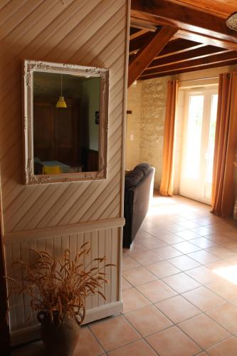 a mirror on the wall of a room with a couch at L'autre Monde Chambres D'hôtes in Faverolles