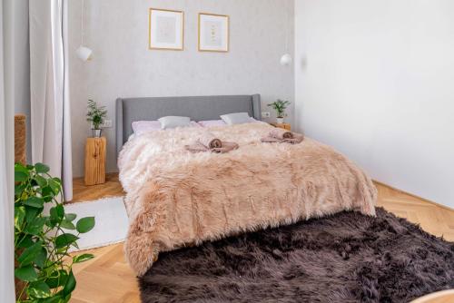 a bedroom with a large bed with a furry blanket at Apartmány Marienhof in Znojmo