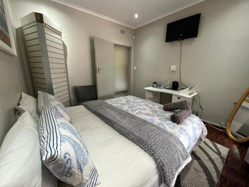 um pequeno quarto com uma cama e um lavatório em Just B Zone Guest House em Joanesburgo