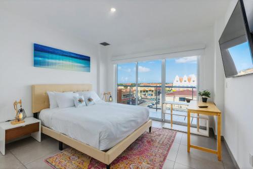 een slaapkamer met een bed en een groot raam bij Family Condo At Downtown in Oranjestad