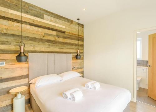 two beds in a bedroom with a wooden wall at Knights Lodges in Newton Solney