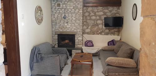 a living room with two couches and a fireplace at Spitiko in Kato Loutraki