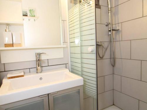 une salle de bain blanche avec un lavabo et une douche dans l'établissement Charmant studio rénové avec grande terrasse, climatisation, parking privé, proche commerces et Thermes - FR-1-553-192, à Balaruc-les-Bains