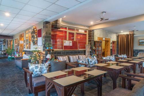 un restaurant avec des tables et des canapés en bois dans l'établissement Starlit Getaway, à Dharamshala
