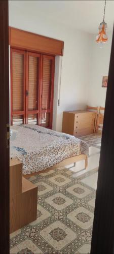 1 dormitorio con 2 camas y alfombra en Appartamento Rione Euro, en Gioiosa Ionica