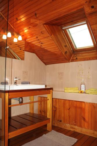 baño con bañera, lavabo y ventana en L'autre Monde en Faverolles