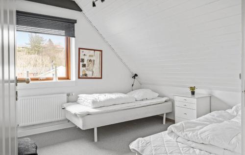 two beds in a white room with a window at Cozy Home In Lemvig With Kitchen in Lemvig