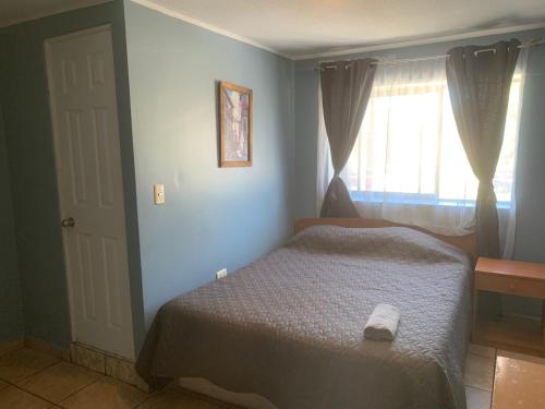1 dormitorio con cama y ventana en HOSTAL QUILPUE, en Quilpué