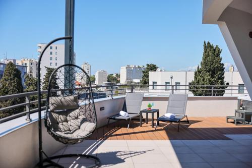 d'un balcon avec des chaises et une balançoire sur le toit. dans l'établissement Luxury Penthouse Berin with Rooftop Terrace and Jacuzzi, à Zadar