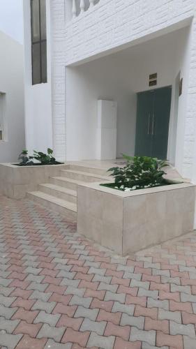 a building with stairs and plants in front of it at البيت الابيض in Mawāliḩ