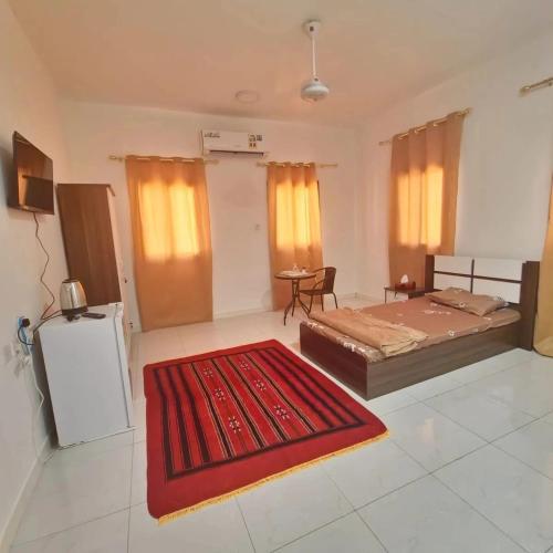 Großes Zimmer mit einem Bett und einem roten Teppich in der Unterkunft البيت الابيض in Mawāliḩ