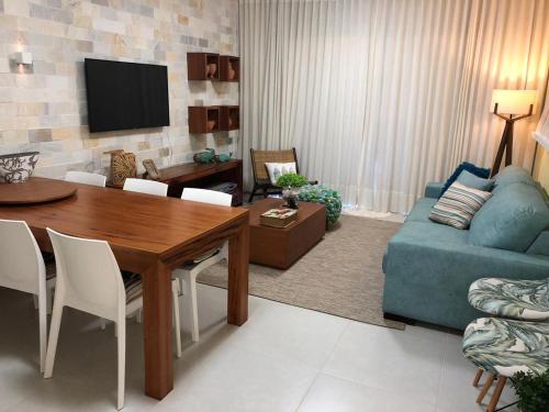 sala de estar con mesa y sofá azul en Apartamento Villa das águas resort, en Estância