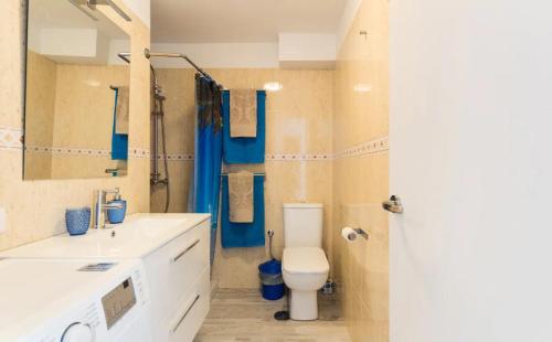 uma casa de banho com um WC, um lavatório e um espelho. em Acogedor y vistas al mar em Maspalomas